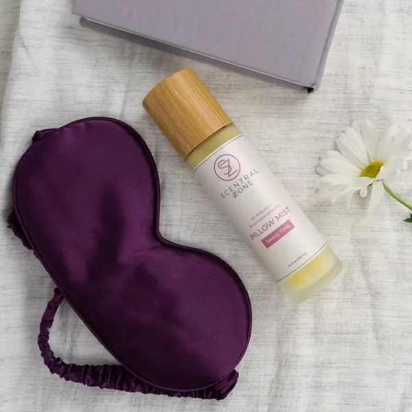 Scentral Zone's Sleepy Time Pillow mist on bed with book, sleep eye mask and flower in a cozy flat lay.