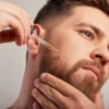 Man with beard applying beard oil to face
